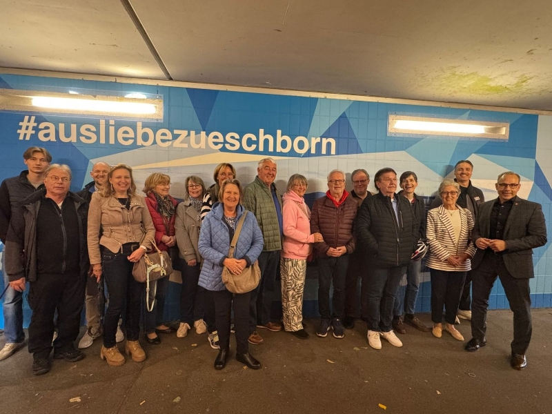 Gruppenfoto vor einem blauen Wandbild mit dem Hashtag ausliebezueschborn anlässlich der Vorstellung einer neu gestalteten Unterführung in Eschborn.
