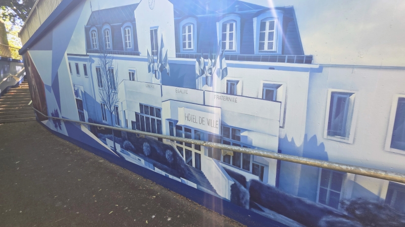 In Blautönen gemaltes Street-Art-Wandbild des Rathauses der französischen Partnerstadt Montgeron in einer Unterführung in Eschborn.
