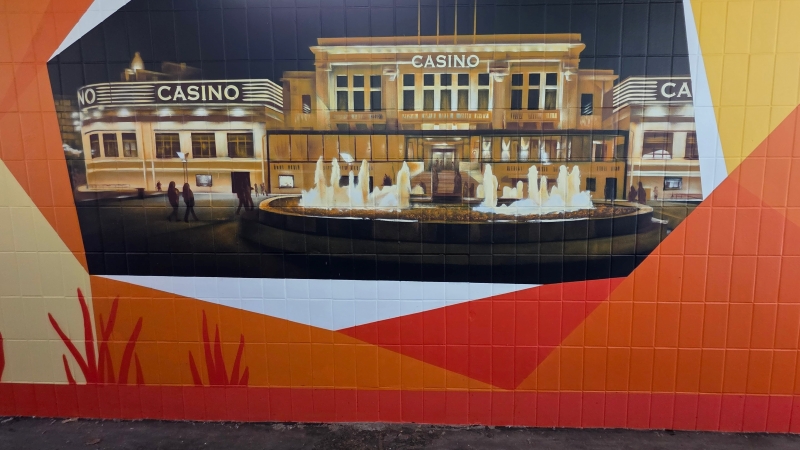 Street-Art-Wandbild des beleuchteten Casinos der portugiesischen Partnerstadt Póvoa de Varzim in einer Eschborner Bahn-Unterführung.