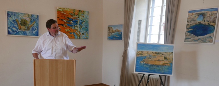Bernd Schiffarth, Vorsitzender des Vereins für Heimatkunde von Adenau, versteigert ein Bild von Josanne Mifsud-Pikutzki. Die Künstlerin stiftete ihr Bild vom Fort St. Angelo in Vittoriosa zugunsten von Praktika von Medizinstudenten aus Malta.